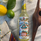 Bottle of Floral Water with decorative label on a textured surface with ceremonial items and fabric.