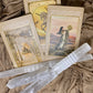 Raw Selenite Sticks placed alongside tarot cards on a textured fabric surface.