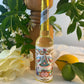 Bottle of 'Agua De Florida',  Floral Water with decorative label on a table with flowers and lemons.