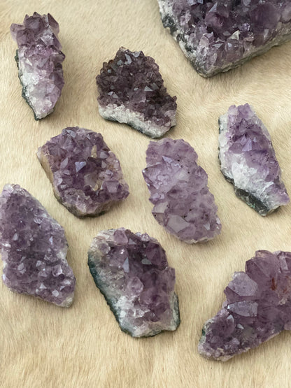 Selection of amethyst crystal pieces on a beige textured background