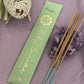 'Prayer' Incense Packaged next to loose incense sticks and an amethyst crystal cluster and a dried  banksia flower.