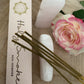 'Love' Incense Packaged next to loose incense sticks a pink and white rose alongside two pink  Mangano crystal wands.