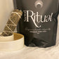 Ceremonial grade cacao with a standing Mugwort smudge stick  next to a black 300g 'Sacred Ritual' bag of Cacao.