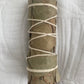 Rolled bundle of Eucalyptus smudge stick tied with twine on a white fabric background
