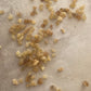 Small pieces of Frankincense resin with warm light coloured tones scattered on a textured surface.