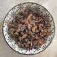 Myrrh resin pieces in a decorative ceramic pinch bowl with a floral pattern on a light speckled background
