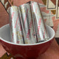 Rolls of Three Kings charcoal rolls in a red and white bowl on a woven patterned surface
