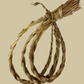 Bundle of sweetgrass braids, rolled into a loop on a light background