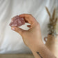 Rose Quartz Chunk being held up by a hand