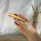 Palo Santo Stick being held up by a hand in front of the screen.